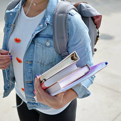 Studente draagt boeken onder de arm